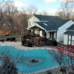 archway deck covered sky light brown railing backyard pool