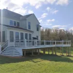 archway deck yellow house side stairs second floor white railing