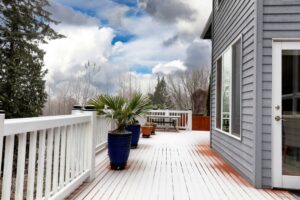Early winter or late autumn snow fall blanketing home outdoor deck