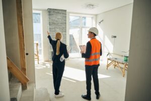 Businesswoman and foreman standing in room which needs redecoration